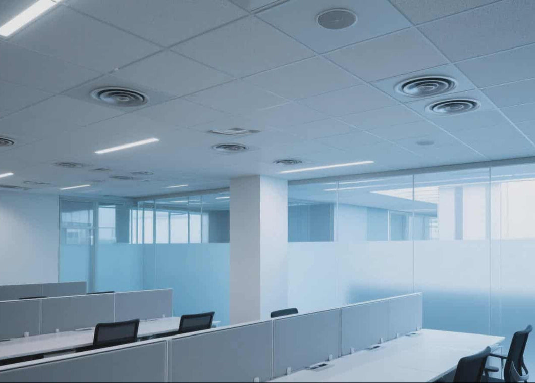 Ceiling view of an office with multiple ceiling lights and air conditioning units.